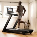 A inclinc and decline tredmill with built-in traing app. User running on tredmill while watching training videos. Tredmill in a well lite area to enhance workout.