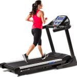 A woman energetically running on a treadmill, focused on her workout.
